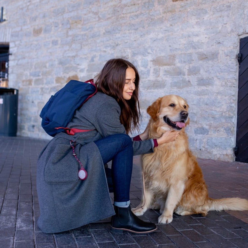 赤色のシティディスクをつけた女性と犬